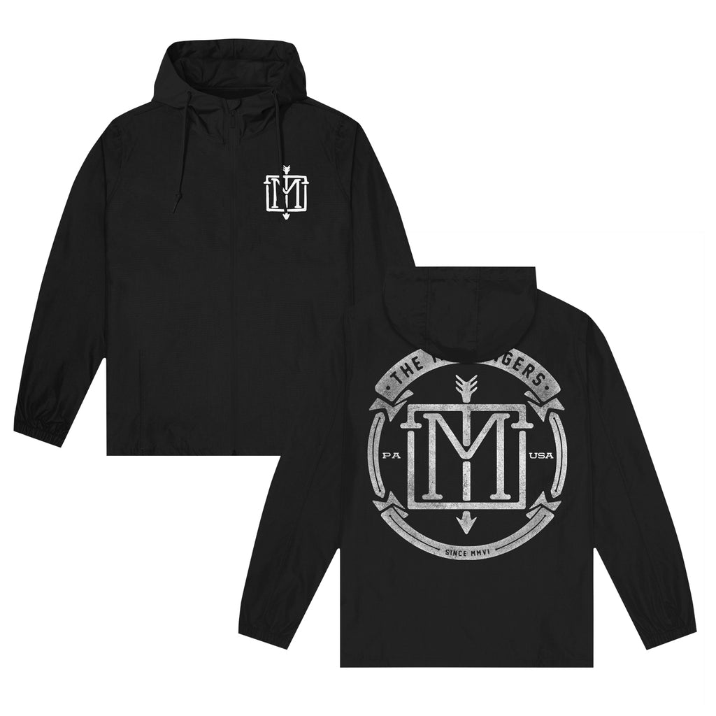 image of the front and back of a black pullover windbreaker jacket on a white background. the front of the jacket is on the left and has a small chest print on the right in white of the menzingers emblem logo. the back of the jacket is on the right and has a full back print in whiteof a circle with the menzingers emblem logo in the center. it also says in arched text at the top the menzingers